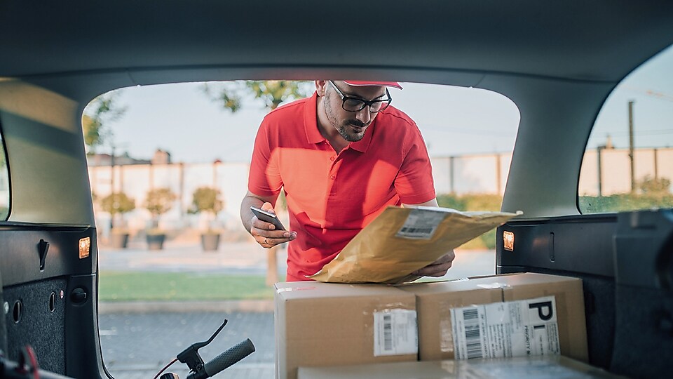 Man checking parcels in backseat of car