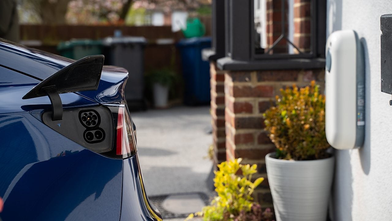 Das Heck eines E-Autos und eine Wallbox.