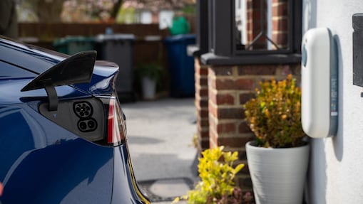 Das Heck eines E-Autos und eine Wallbox.