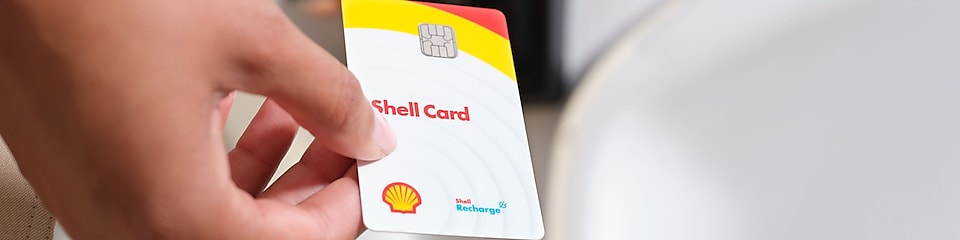 Die Shell Card wird über die Ladentheke gereicht.
