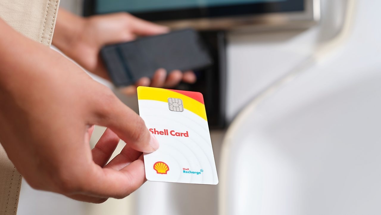 Die Shell Card wird über die Ladentheke gereicht.