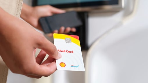 Die Shell Card wird über die Ladentheke gereicht.