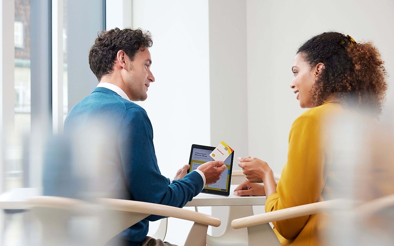 Zwei Kollegen sprechen im Büro über die Shell Card