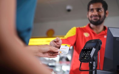 Eine Shell Card wird über die Kasse gereicht.