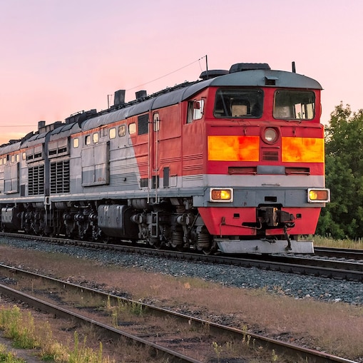 Ein Zug fährt an einem Bahnsteig vorbei.