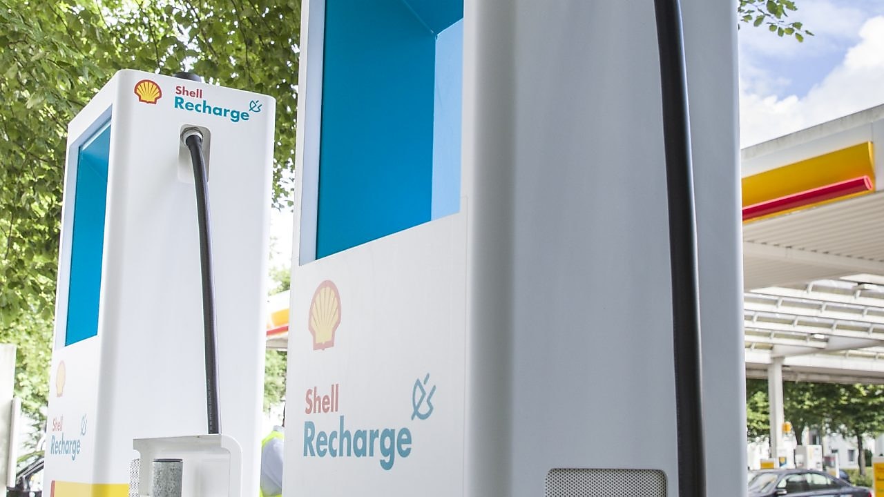 Zwei Shell Recharge Schnellladesäule vor einer Shell Station