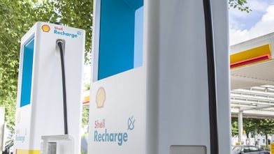 Zwei Shell Recharge Schnellladesäule vor einer Shell Station