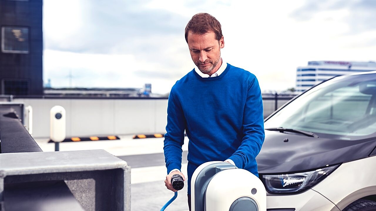 Der Fahrer lädt sein E-Fahrzeug an einer E-Mobility Ladestation.