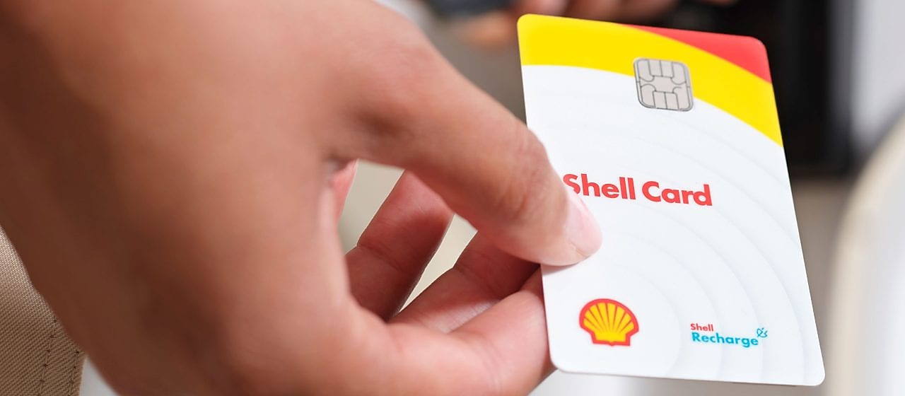 Hybride Shell Card mit sechs Vorteils-Icons. Im Hintergrund eine Draufsicht einer Autobahn mit Verkehr.