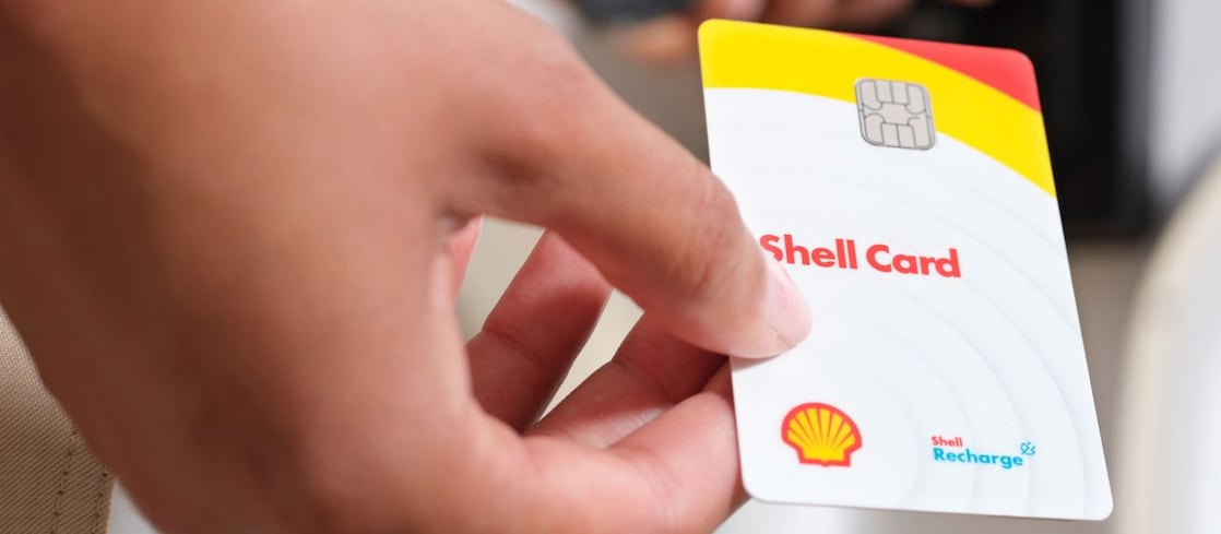 Hybride Shell Card mit sechs Vorteils-Icons. Im Hintergrund eine Draufsicht einer Autobahn mit Verkehr.