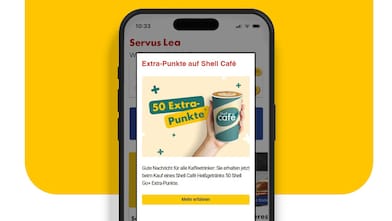 Smartphone-Screen mit Shell-App-Popup, das 50 Extra-Punkte beim Kauf eines Shell Café-Heißgetränks bewirbt. Darunter ein gelber „Mehr erfahren“-Button.