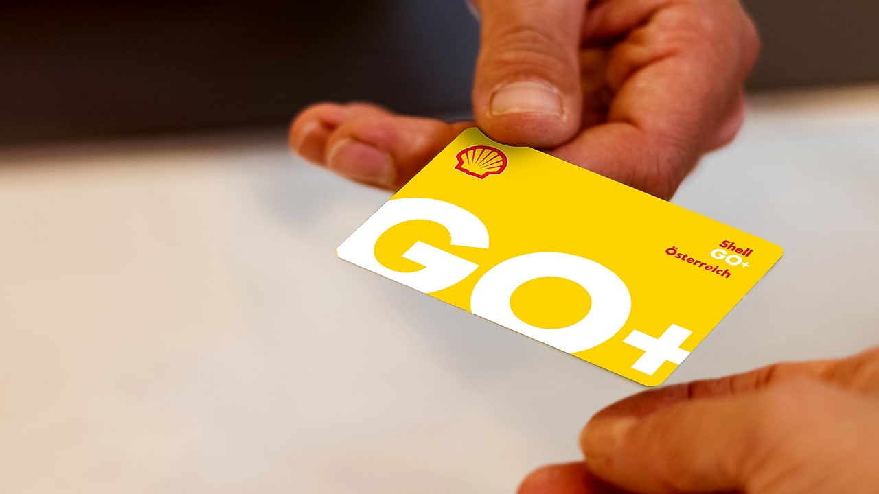 Hand gibt physische Go+ Karte einer anderen Hand.