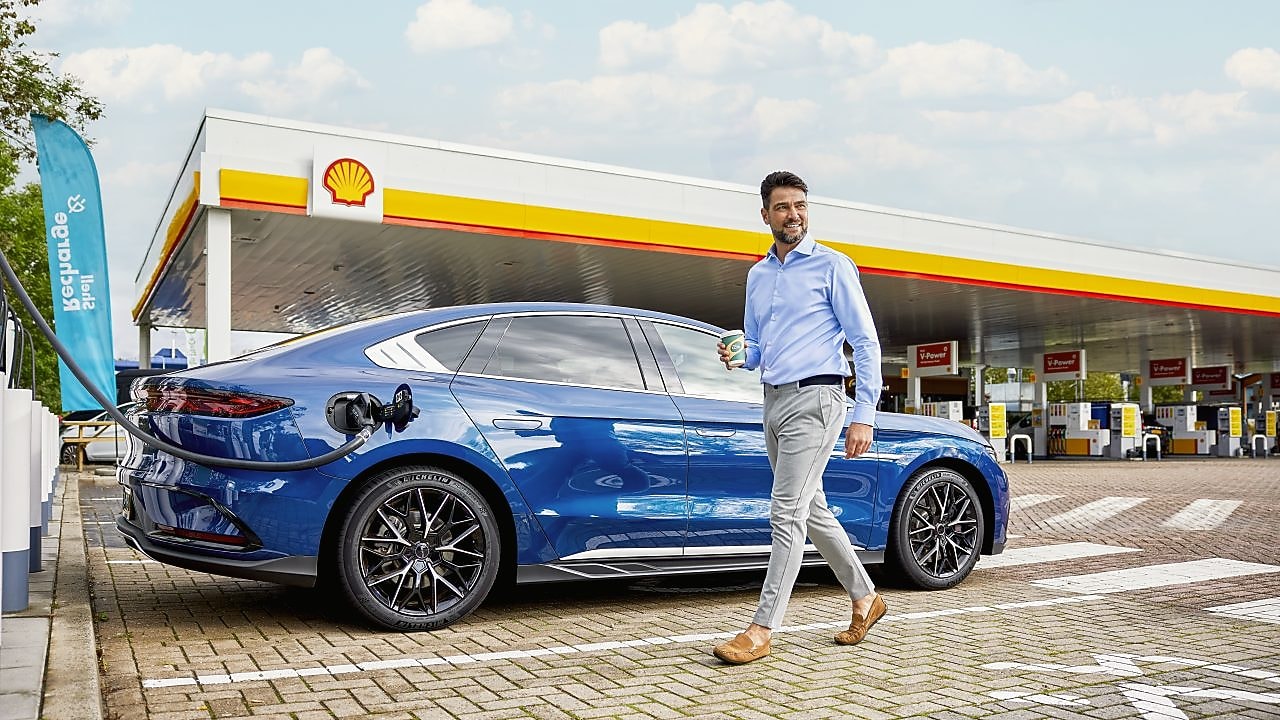 Mann lädt sein E-Auto an einer Shell Recharge Schnellladesäule an einer Shell Station