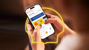 Frau hält in der Hand ein Handy mit geöffneter Shell App und sieht sich Shell Go+ Angebote an.
