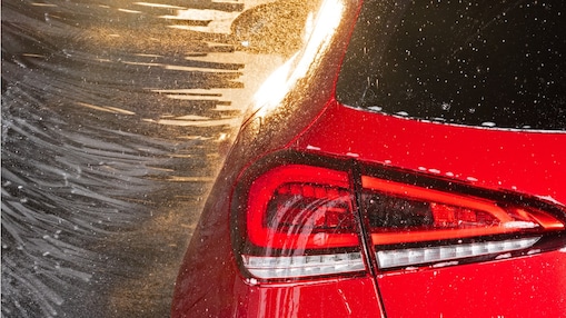 Detailansicht von einem Rücklicht eines roten Fahrzeugs in der Waschanlage, symbolisch für Shell Car Wash.