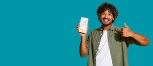 Lächelnder junger Mann mit der neuen Shell App auf dem Smartphone