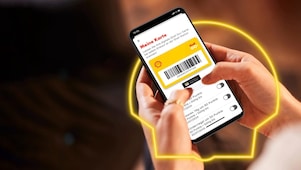 Frau hält in der Hand ein Handy mit geöffneter Shell App und sieht sich Shell Go+ Angebote an.